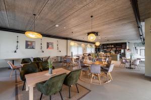 a restaurant with wooden ceilings and tables and chairs at Viešbutis SAKAI sodyboje Gribžė in Gribžiniai