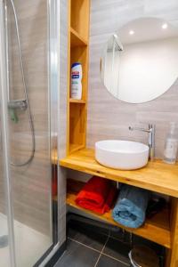 La salle de bains est pourvue d'un lavabo, d'une douche et d'un miroir. dans l'établissement Le Poète - T2 avec Terrasse - Métro Saint Cyprien, à Toulouse