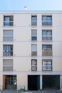 - un grand bâtiment blanc avec des fenêtres et des balcons dans l'établissement Le Poète - T2 avec Terrasse - Métro Saint Cyprien, à Toulouse