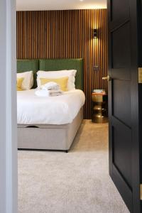 a bedroom with a bed with a green headboard at Luxury Lodge with Hot Tub at Lindores in Newburgh