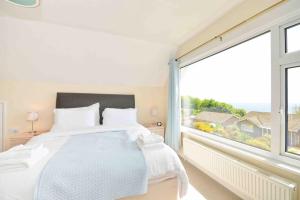 a bedroom with a bed and a large window at Tara, Spacious Family Home, Wonderful Sea Views in Ventnor +30 photos