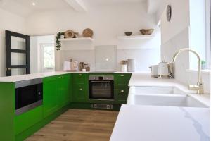 a green kitchen with white counters and a sink at Luxury Lodge with Hot Tub at Lindores in Newburgh