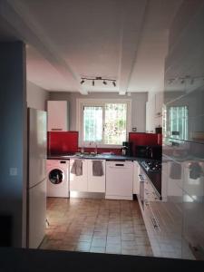 a kitchen with white cabinets and a tile floor at Maison au calme vue montagnes in Vence