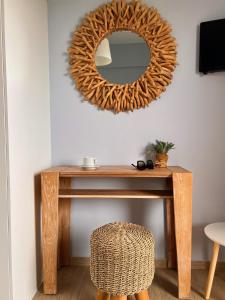 a mirror on a wall above a wooden table with a stool at Stella in the Village Junior Studio Sea View II in Plakias