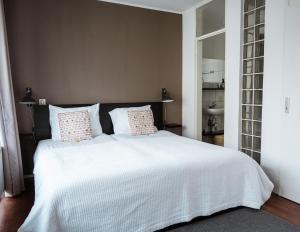 a bedroom with a large white bed with two pillows at Center Appartement Apeldoorn in Apeldoorn