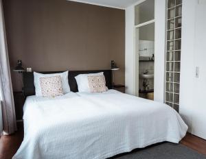 een slaapkamer met een groot wit bed met 2 kussens bij Center Appartement Apeldoorn in Apeldoorn