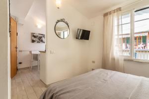 a bedroom with a bed and a mirror and a window at WanderJohn penthouse 5terreparco in Riomaggiore