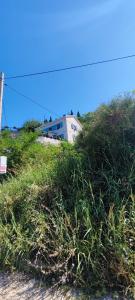 a building sitting on top of a grass covered hill at Lastva star in Donja Lastva