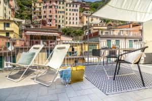 un paio di sedie e un tavolo sul balcone di WanderJohn penthouse 5terreparco a Riomaggiore