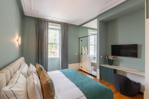 a bedroom with a large bed and a television at Maison Bleue in Porto