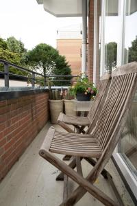 een paar houten stoelen op een veranda bij Center Appartement Apeldoorn in Apeldoorn