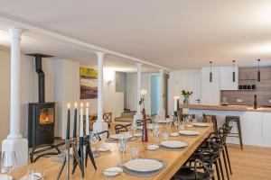 uma sala de jantar com uma mesa longa e uma lareira em B&B - La Maison des Sottais em Burg-Reuland