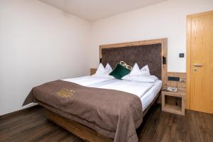 a bedroom with a large bed with a wooden headboard at SONNLEITEN Alpin Hotel in Cadipietra +168 photos