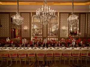 une salle à manger avec une grande table et des lustres dans l'établissement Hôtel Plaza Athénée - Dorchester Collection, à Paris