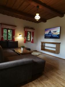 a living room with a couch and a tv on the wall at Chata Šeřín in Vítkovice