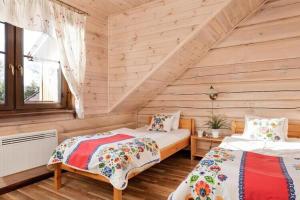 a bedroom with two beds in a log cabin at Comfortable 2 storey holiday home Ustronie Morskie in Ustronie Morskie