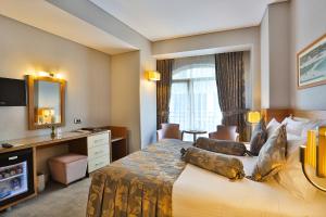 イスタンブールにあるHotel Momento - Special Categoryの大型ベッドとテレビが備わるホテルルームです。