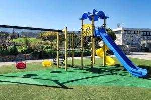 a playground with a blue and yellow slide at 2 bedroom ground floor apartment in Kalogrea