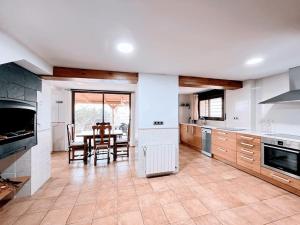 a kitchen with a table and a dining room at Casa de vacaciones en castelldefels ¡tranquilidad y piscina! in Castelldefels