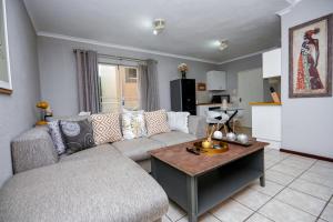 a living room with a couch and a table at Cosy Hatfield Apartment in Pretoria
