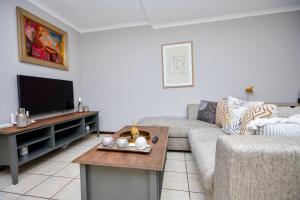 a living room with a couch and a tv at Cosy Hatfield Apartment in Pretoria