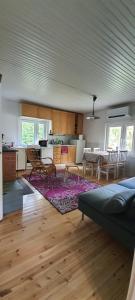 eine Küche und ein Wohnzimmer mit einem Sofa und einem Tisch in der Unterkunft Jämsän Himoksen torppa Savusaunalla in Jämsä