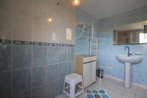 a blue tiled bathroom with a sink and a toilet at La Glycine in Auxant +22 photos