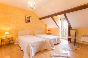a bedroom with two beds and a window at La Glycine in Auxant