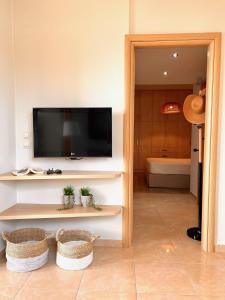 a living room with a flat screen tv on a wall at Stella in the Village Studio Sea View in Plakias