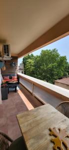 balkon z drewnianym stołem i dużym oknem w obiekcie Casa avignonnaise w Awinionie