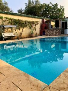 una piscina de agua azul en un patio en Maison de vacances avec piscine privèe, en Fez