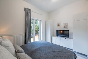 a bedroom with a bed and a flat screen tv at Neues Ferienhaus an der Ostsee+Terrasse+Sauna in Surendorf
