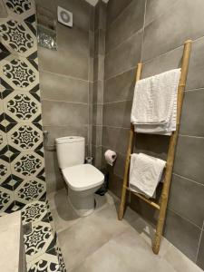 a bathroom with a toilet and towels on a wall at Xenios Hotel in Pefkochori