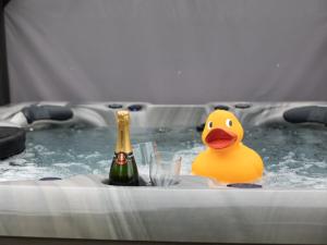 a rubber duck in a hot tub with a bottle of champagne at Beecham Farmhouse in Stratford-upon-Avon