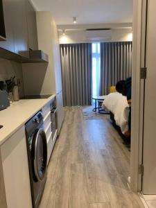 a kitchen with a washer and dryer in a room at Entire Studio Apartment @MenlynMaine in Pretoria