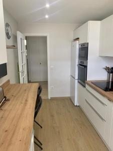 a kitchen with a wooden table and white cabinets at Le Roxane 2 bedroom apartment in the city-center of Antibes in Antibes
