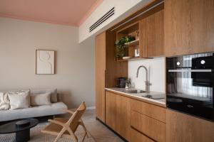 une cuisine avec un évier et un canapé dans une chambre dans l'établissement GoodHouse 401 - Beautiful Flat in Center of Jerusalem, à Jérusalem