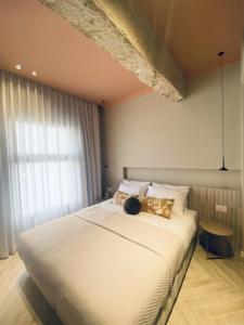 1 dormitorio con 1 cama blanca grande y ventana en GoodHouse 401 - Beautiful Flat in Center of Jerusalem, en Jerusalén