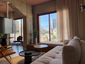- un salon avec un canapé et une grande fenêtre dans l'établissement GoodHouse 401 - Beautiful Flat in Center of Jerusalem, à Jérusalem