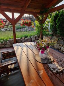 een houten tafel met een vaas met bloemen erop bij Pension MAX in Pernink