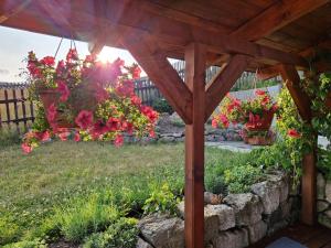 una pérgola de madera con flores en un patio en Pension MAX, en Pernink