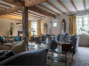 a living room with couches and a table at Beecham Farmhouse in Stratford-upon-Avon