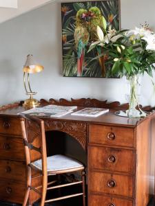 a wooden desk with a chair and a vase of flowers at Beecham Farmhouse in Stratford-upon-Avon