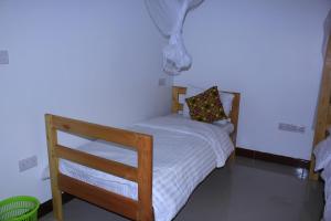 a small bedroom with a bed with white sheets at IOP Cabin Ilula 