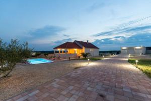 a home with a brick driveway and a house at Villa Zrilic ZadarVillas in Perušić Benkovački