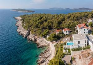 Luftaufnahme eines Strandes mit Häusern und dem Meer in der Unterkunft Amazing Seafront Croatian Villa 5 Bedrooms Villa Primosten Pearl in Primošten