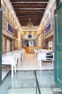 une salle à manger avec des tables et des chaises blanches dans l'établissement Al Mascaron Ridente, à Venise