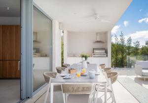 eine Küche und ein Esszimmer mit einem weißen Tisch und Stühlen in der Unterkunft Amazing Seafront Croatian Villa 5 Bedrooms Villa Primosten Pearl in Primošten + 32 Fotos