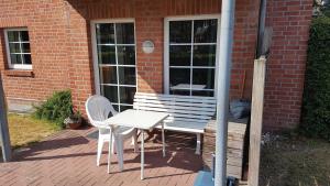 a white table and chairs sitting on a porch at Ferienwohnung Mueller_ 15121 in Leer