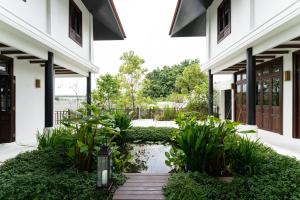 een binnenplaats van een huis met een vijver en planten bij Siri Sala Private Thai Villa in Bangkok